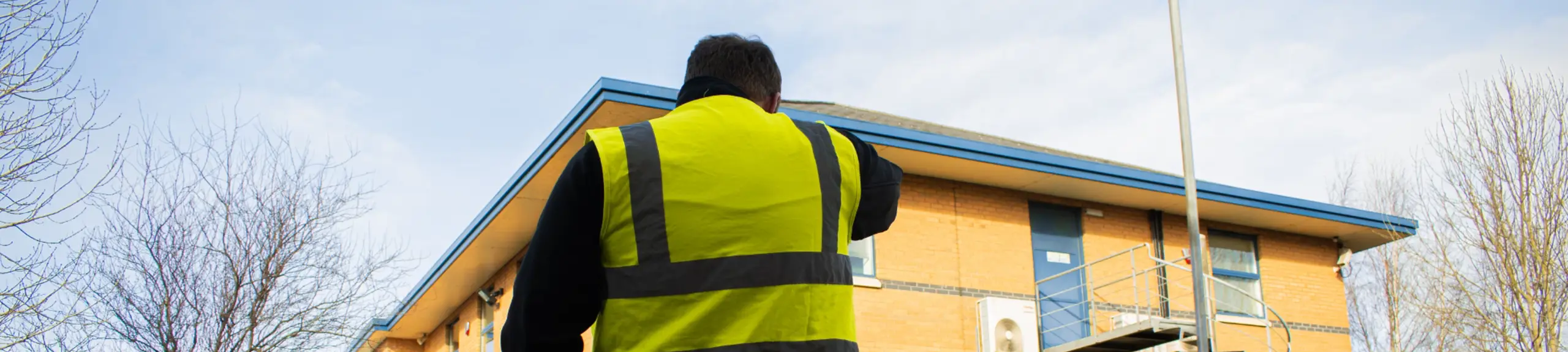 a man in a hi vis outside a building a man in a hi vis outside a building